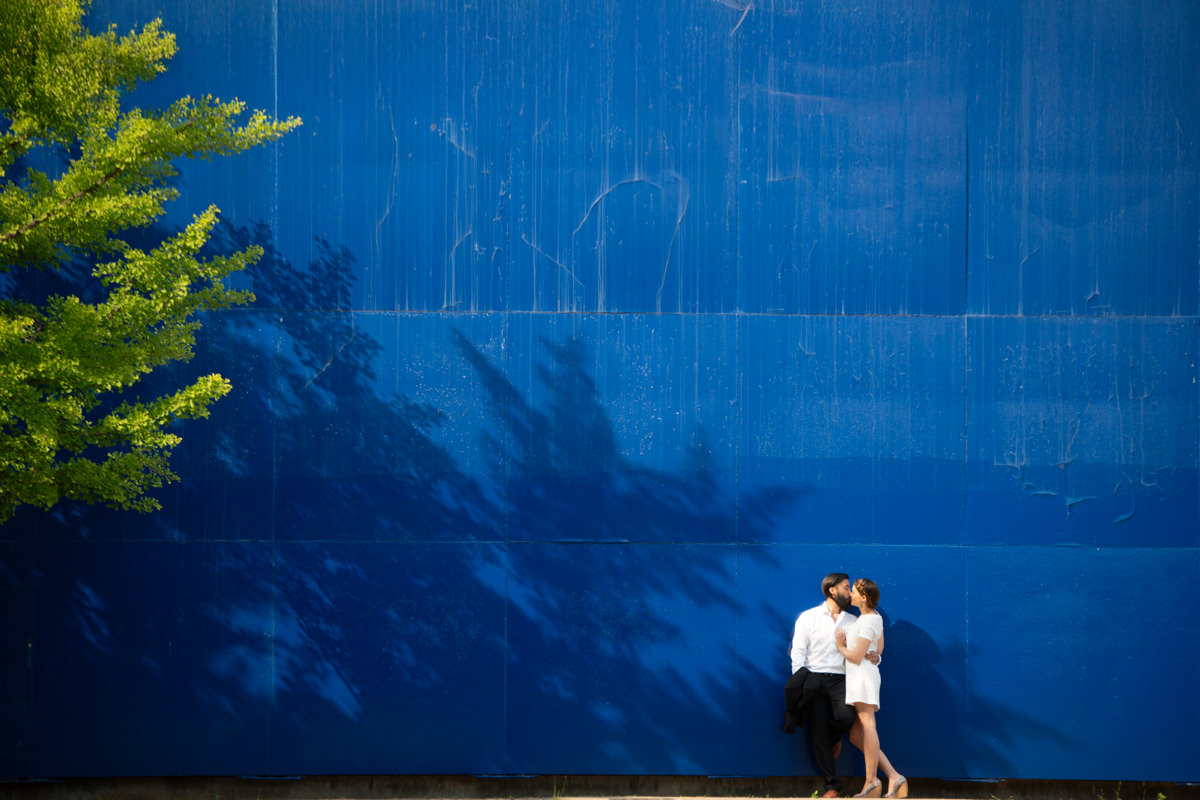 Couple de mariés devant un mur bleu